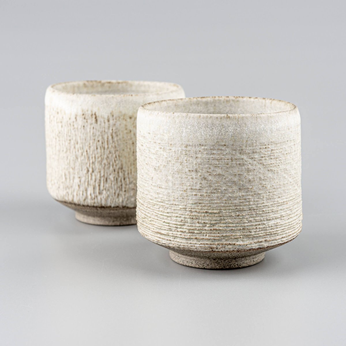 Handcrafted pottery mugs with white matte glaze, ideal for coffee, tea, and collectible kitchenware.