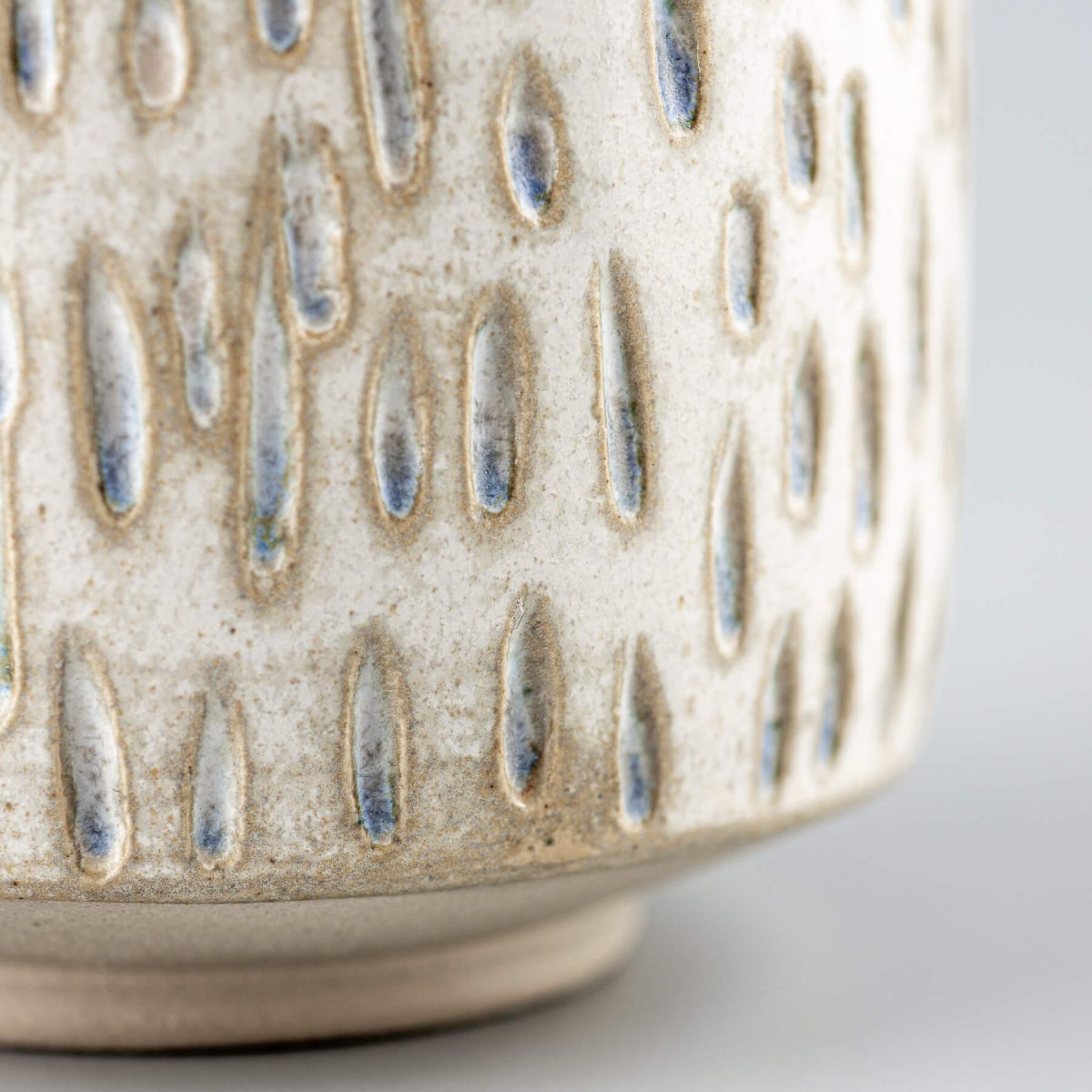 Handcrafted ceramic espresso cup with droplet carvings, highlighting artisan texture for home and fine dining.