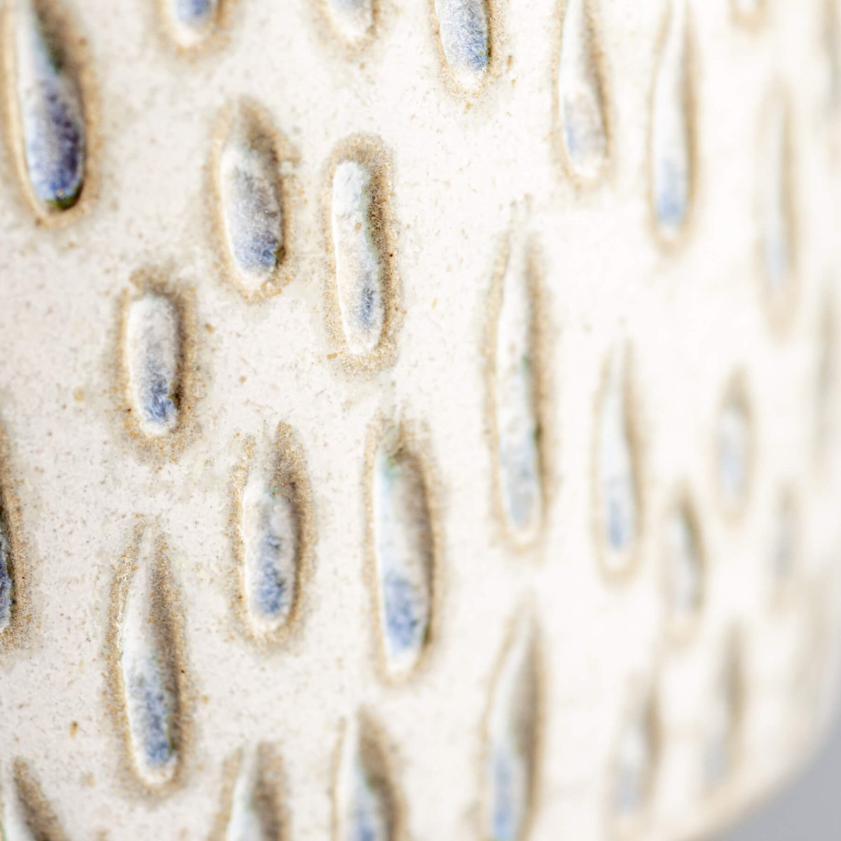 Detail of carved ceramic espresso cup with handmade droplet pattern, perfect for boutique hotel tableware.