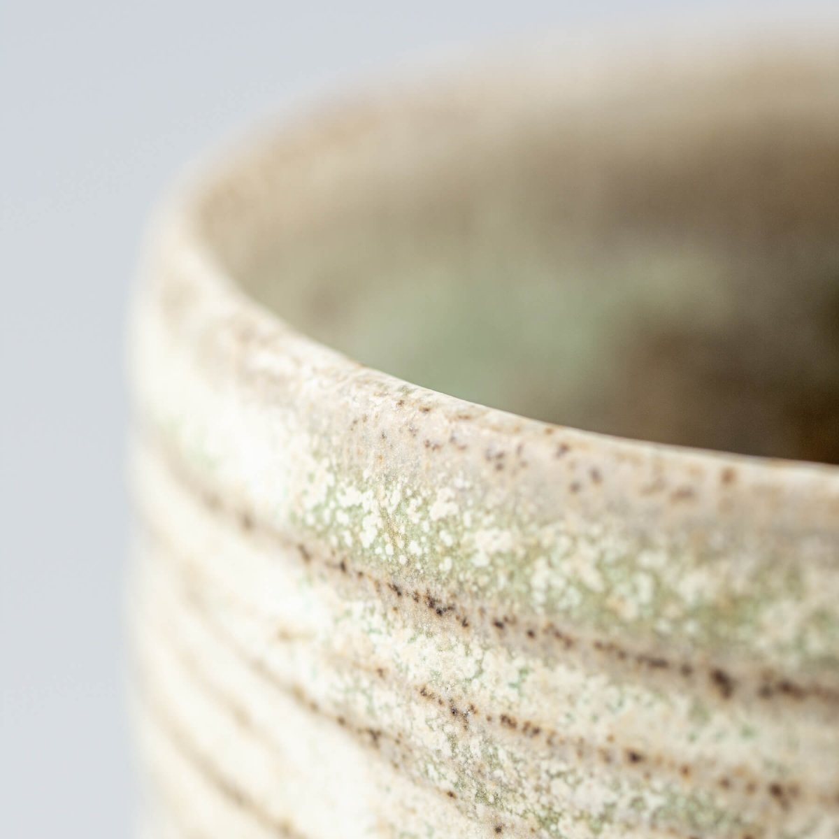 Unique handmade mug with subtle green glaze, suitable for home and culinary presentation.