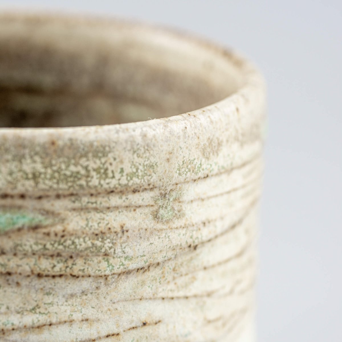 Ceramic handmade mug with rustic carved design, ideal for collectible pottery lovers.