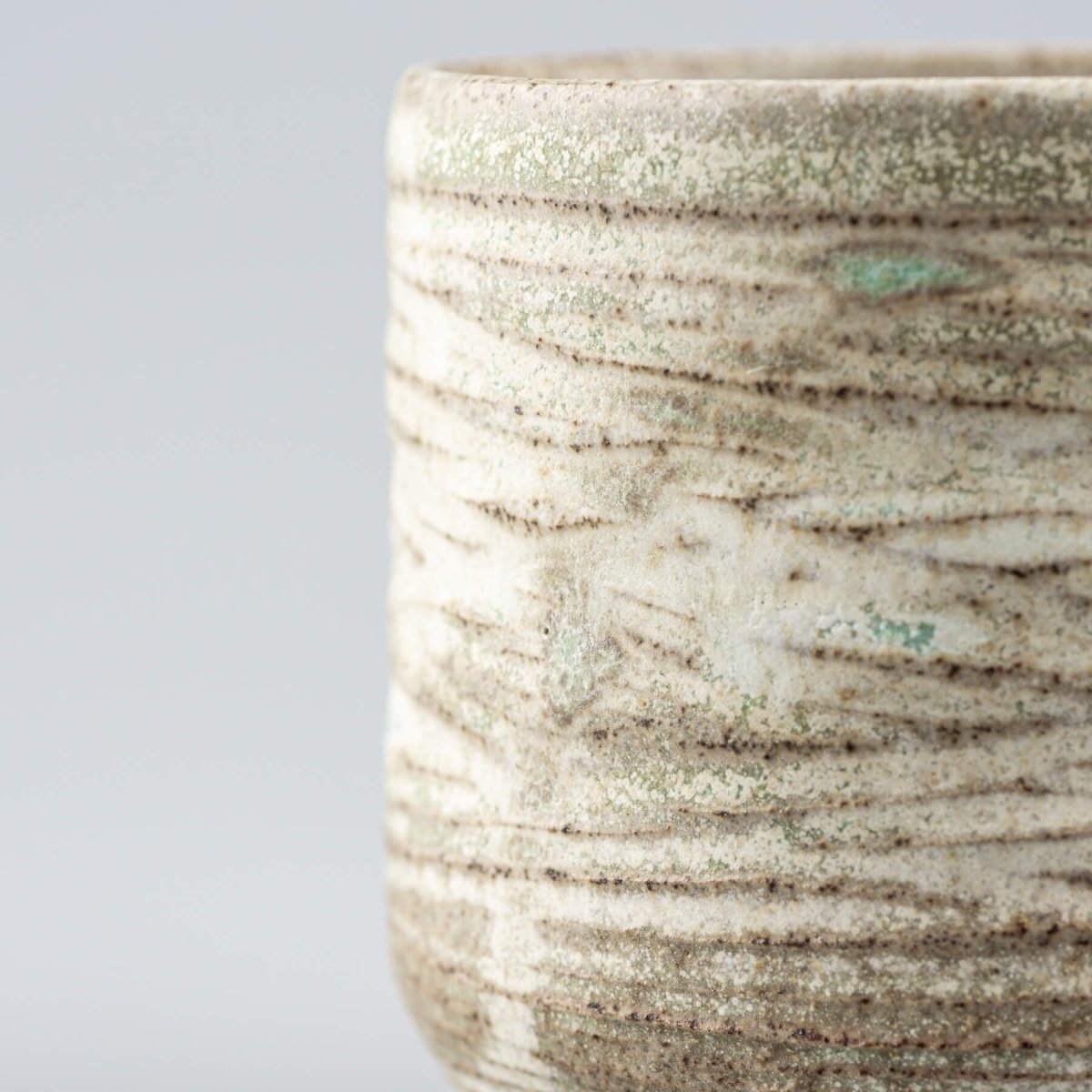 Stoneware handmade mug with artistic surface, blending modern kitchenware and handmade decor.