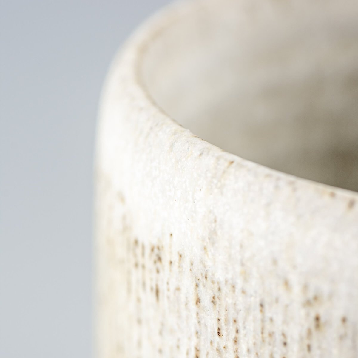 Handcrafted ceramic mug rim with matte glaze, showcasing artisanal pottery design.
