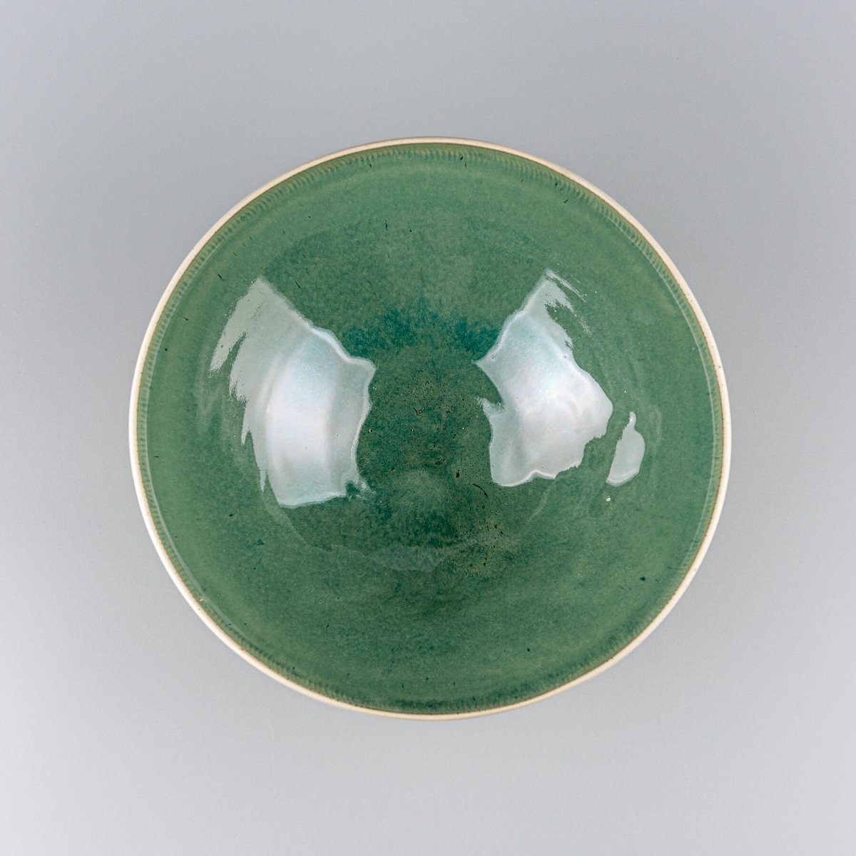 Top view of large ceramic bowl showing smooth green glazed surface and wide open profile.