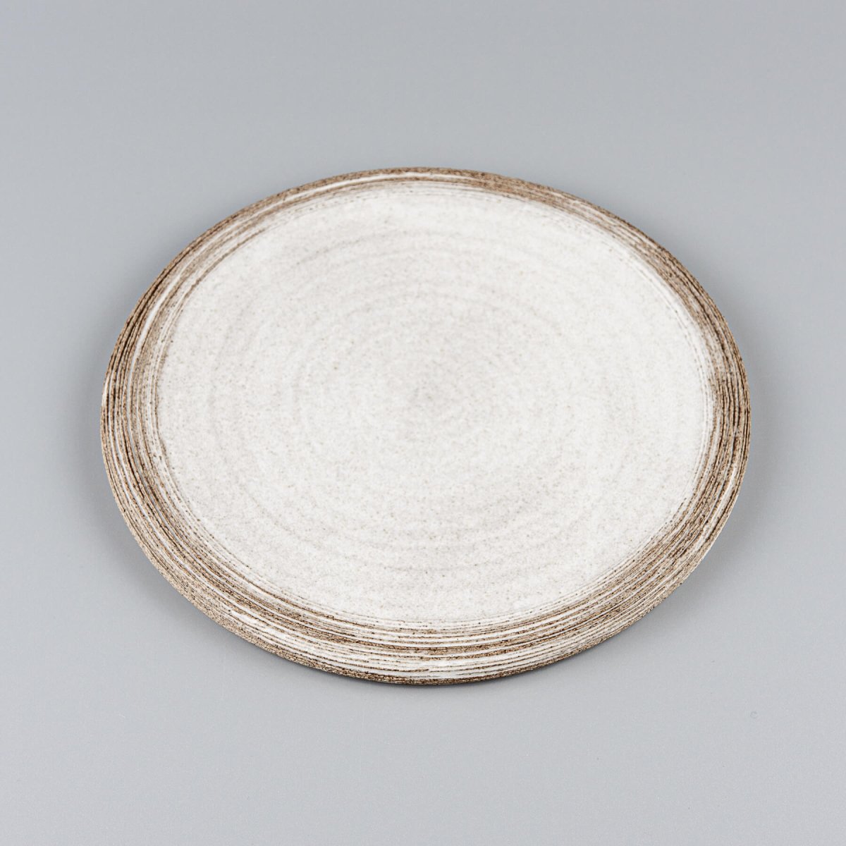 Top view of premium flat ceramic plate with hand-carved edges for culinary presentation.