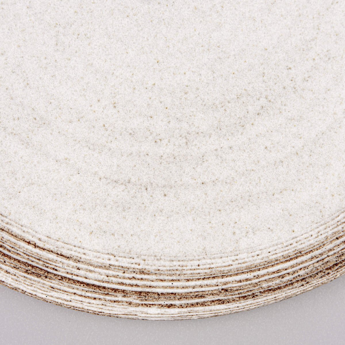 Close-up of matte white glaze contrasting with natural dark stoneware.