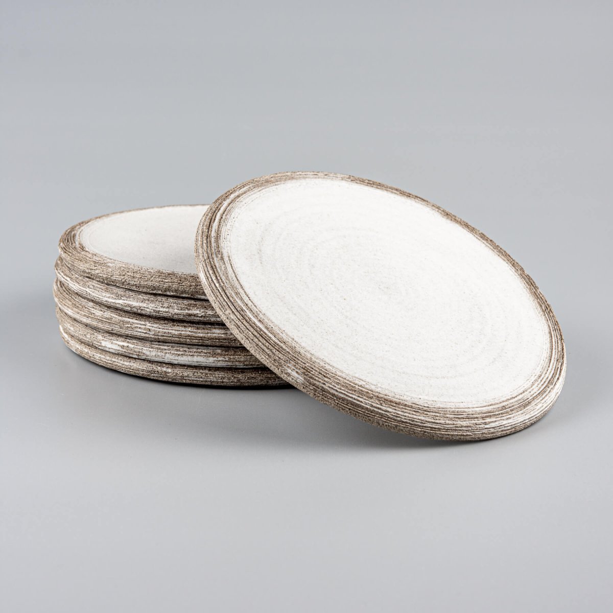 Stack of luxury handmade ceramic plates with minimalist design for premium culinary presentation.