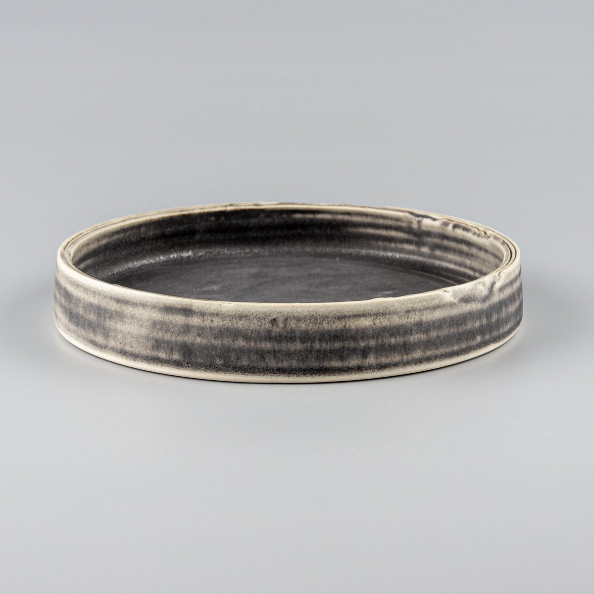 Elegant handmade ceramic plate with deep olive-green glaze and straight edges, perfect for fine dining presentation.