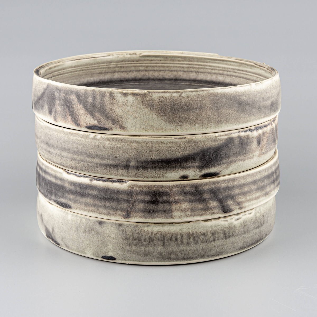 Stack of handmade ceramic plates designed for premium dining experiences in restaurants and boutique hotels.