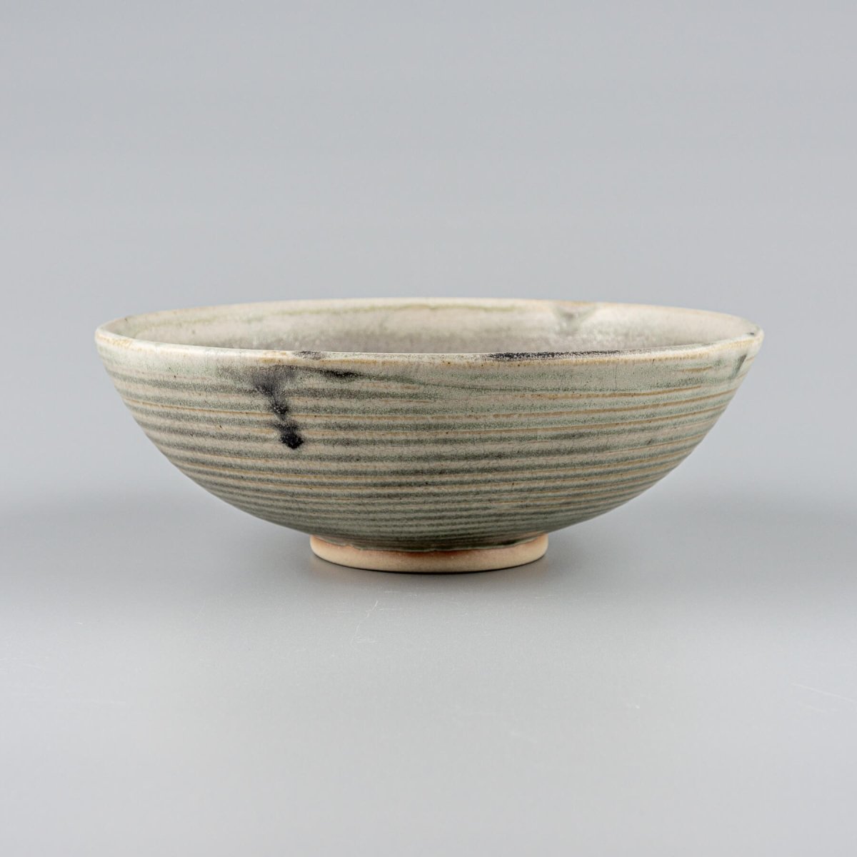 Artisan ceramic bowl with olive matte glaze and hand-carved stoneware texture for kitchenware and collectible pottery.