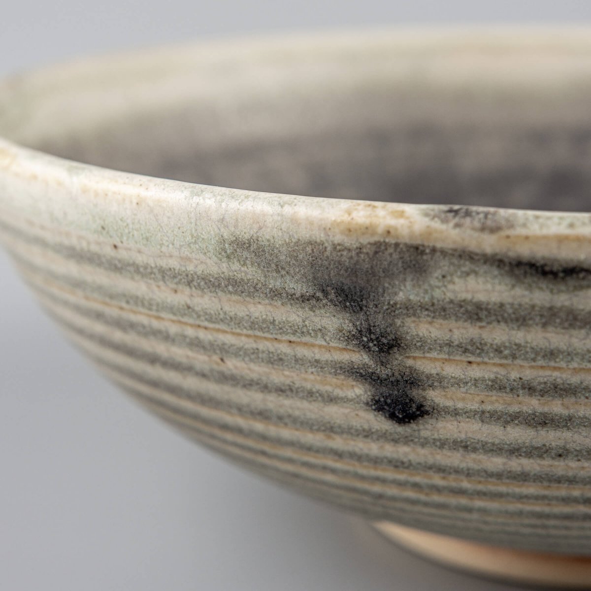 Handmade ceramic bowl with unique beveled form and contrast of smooth glaze and natural clay body.