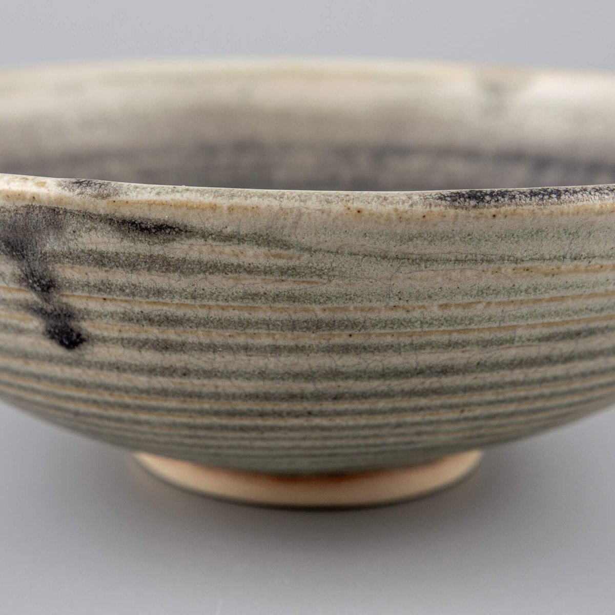 Collectible pottery bowl with olive green interior glaze and sculptural form, designed for elevated dining experiences.