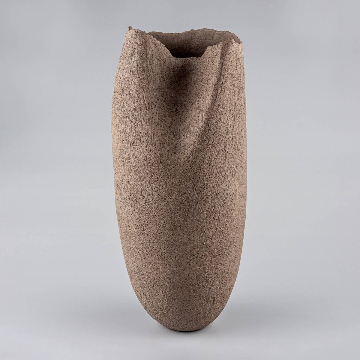 Handmade stoneware vase with a sculptural, organic shape, perfect for a hotel or restaurant's centerpiece.