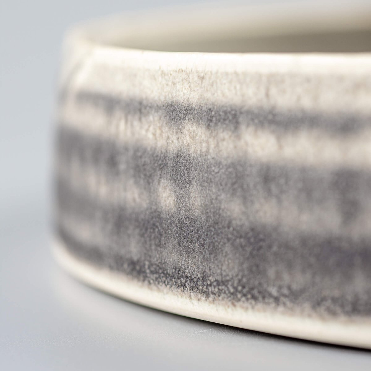 Close-up of plate’s side showing refined stoneware texture and artisan glaze finish.