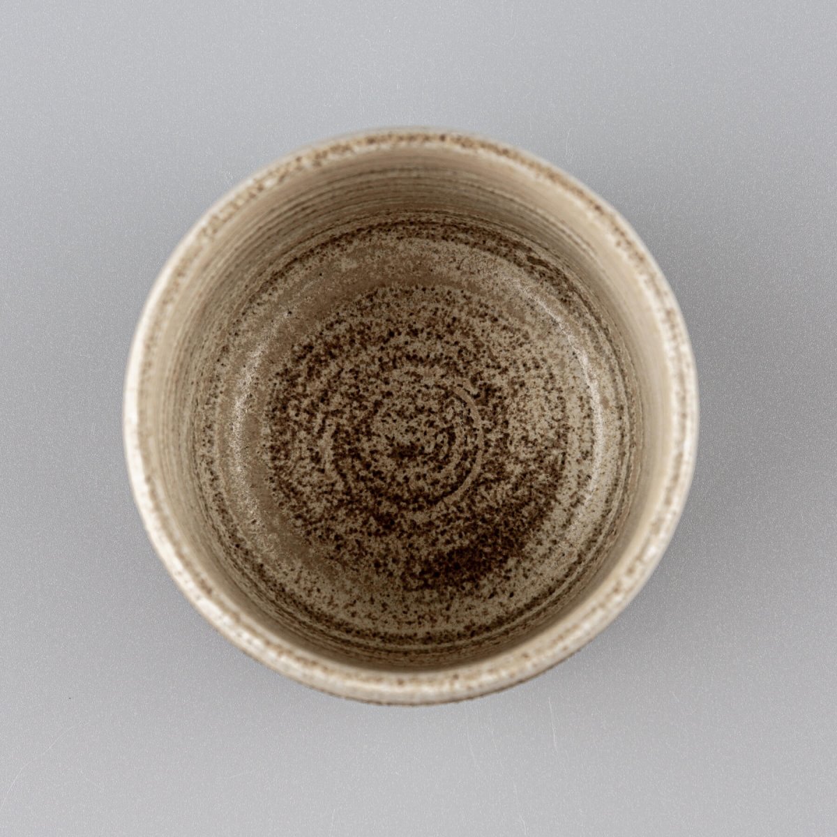 Top view of pottery coffee mug showing smooth matte glazed interior in natural stoneware tones.