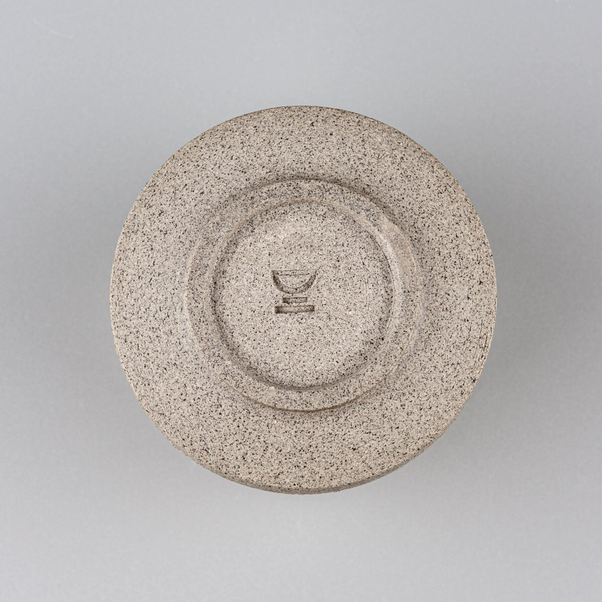 Base of pottery coffee mug in dark stoneware clay with handcrafted circular finish.