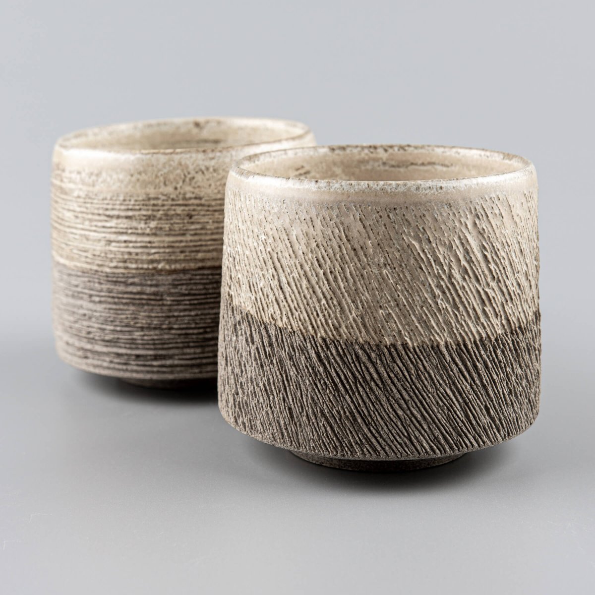 Handcrafted pottery coffee mug set in stoneware with textured carved exterior and matte glaze finish.