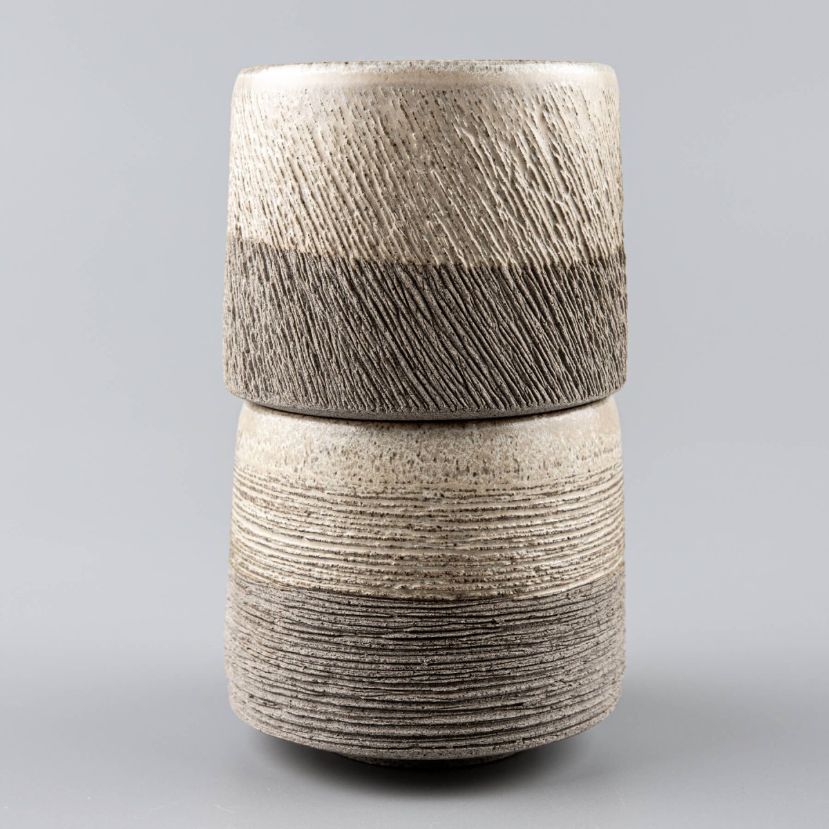 Close-up of pottery coffee mug showing hand-carved stoneware texture and natural matte glaze.