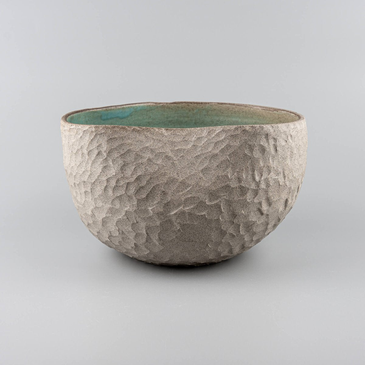 Handmade ceramic vases with a textured stoneware surface and a turquoise-glazed interior, perfect for interior design.