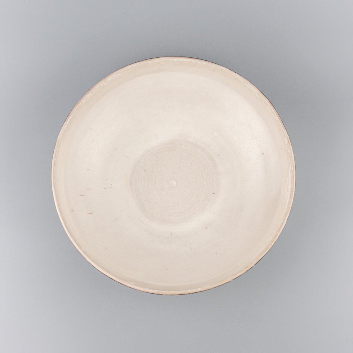 Top view of a wide handmade ceramic centerpiece bowl with glazed interior and textured exterior.