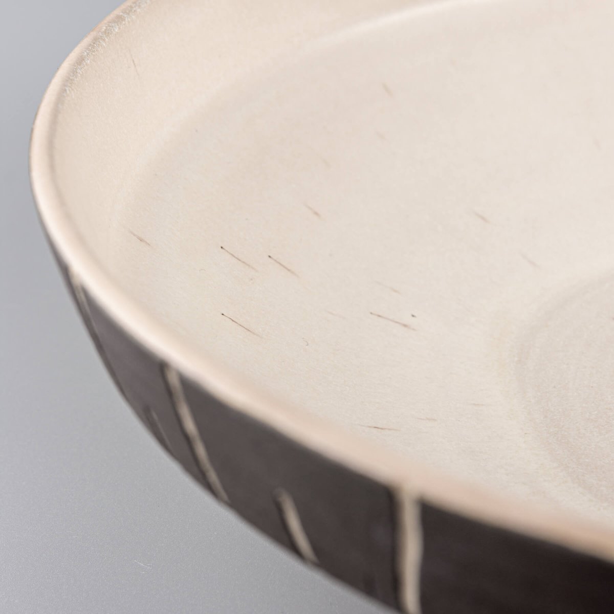Close-up of smooth matte glaze on interior surface of handmade ceramic centerpiece.