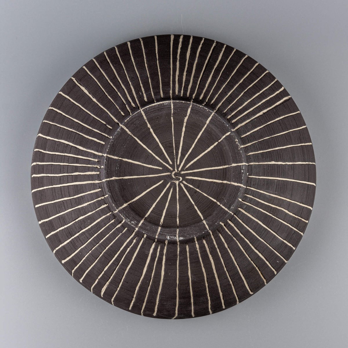Bottom view of handcrafted decorative bowl showcasing detailed foot and carved lines.