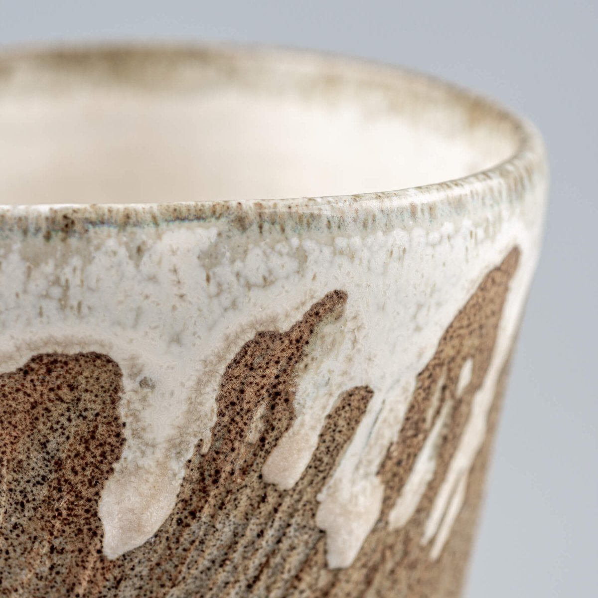 Rustic ceramic espresso mug with tactile carved lines and semi-gloss finish.