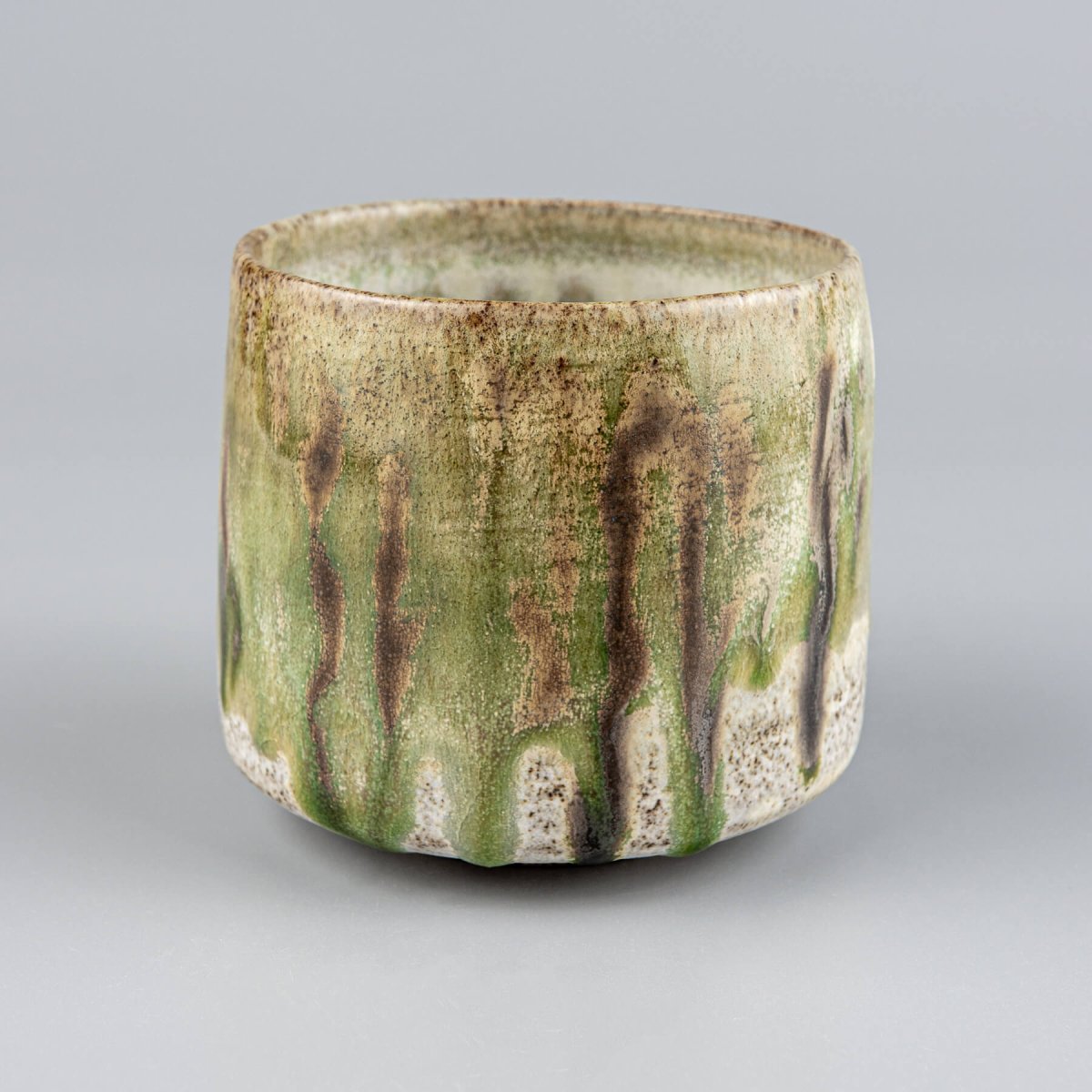 Luxury ceramic coffee and tea mug with earthy green and brown artistic glazing.