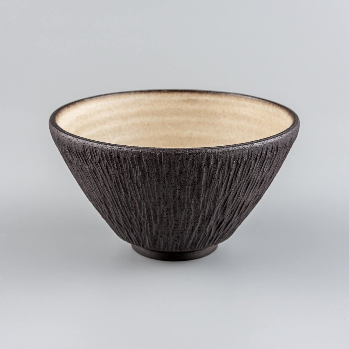 Set of black ceramic bowls with textured exteriors, designed for fine dining tableware collections.