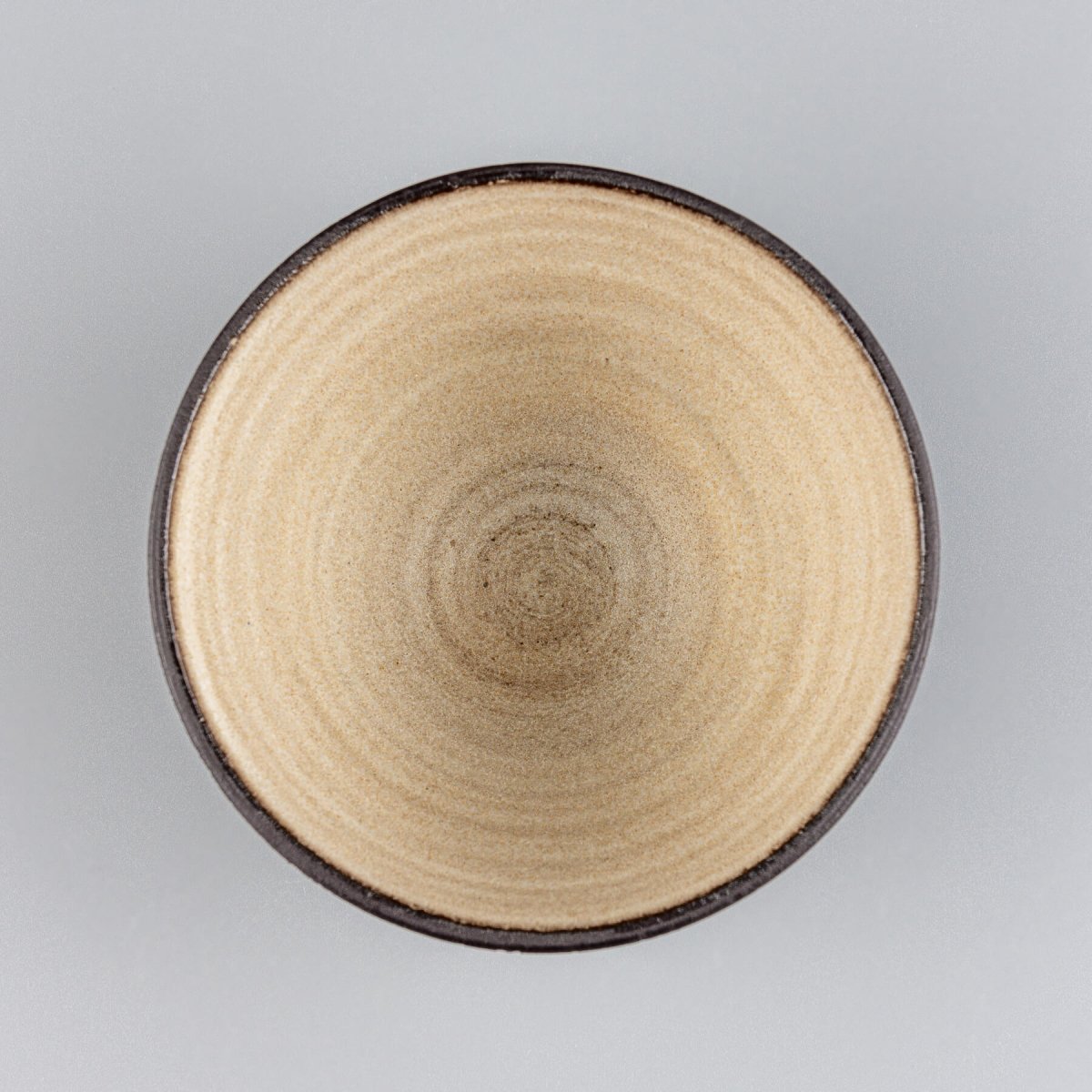 Top view of handcrafted stoneware bowl with minimalist beige glaze and sculptural design.