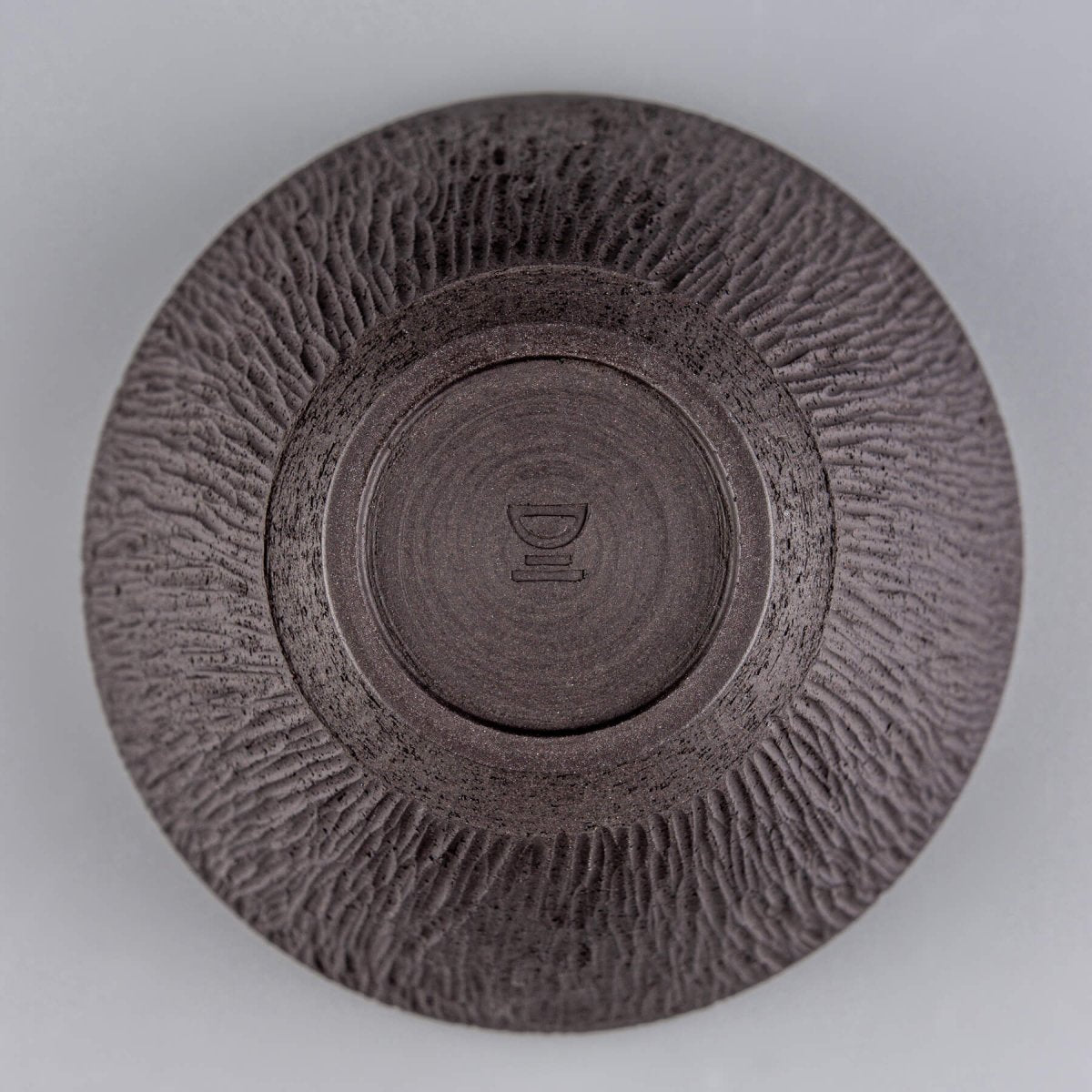Bottom of the ceramic bowl showing handcrafted signature and footed base.
