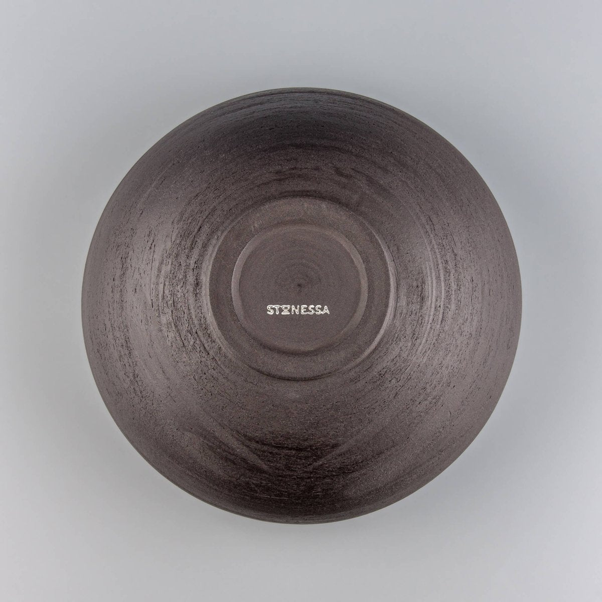 Interior detail of handmade serving bowl with circular wheel marks, speckled glaze, and ceramic fruit bowl style.