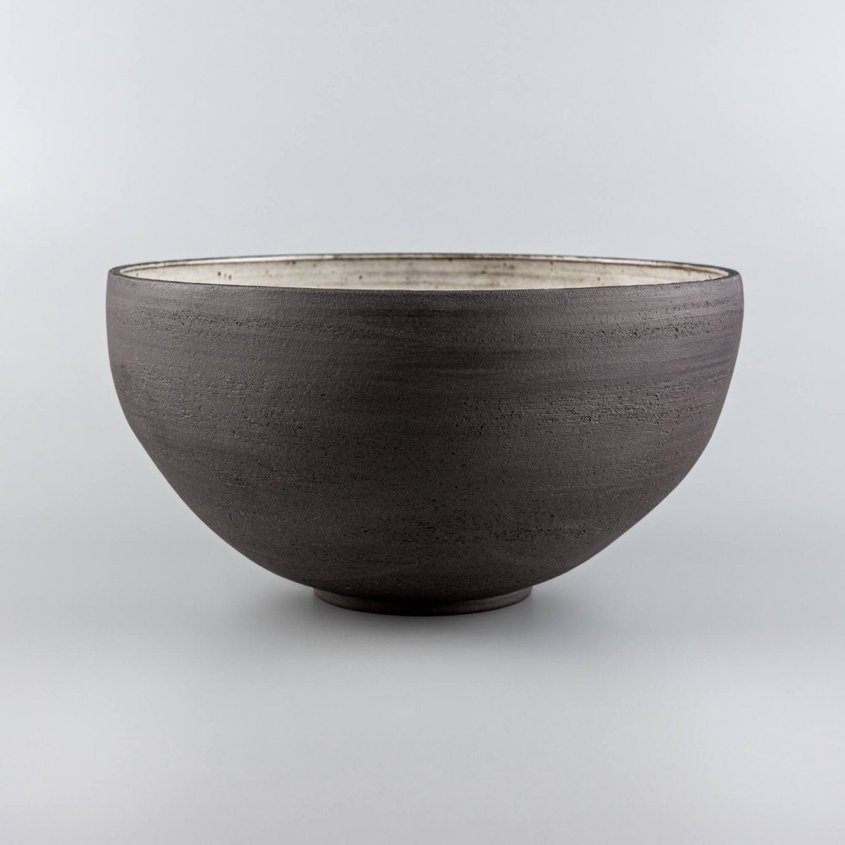 Decorative serving bowl showing cream speckled glaze, wheel-thrown lines, and fine dining serving shape.