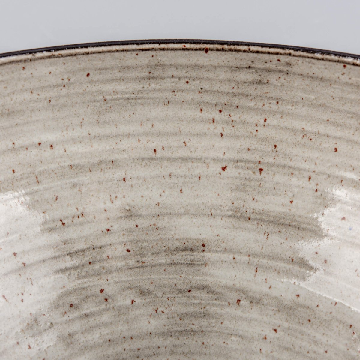 Close-up of handmade serving bowl exterior with charcoal clay texture, dark rim, and modern handmade decor feel.
