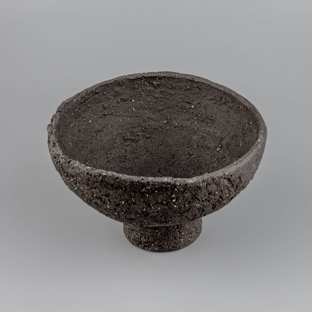 Top view of handmade decorative bowl with dark textured interior, irregular rim, and refined handmade decor character.