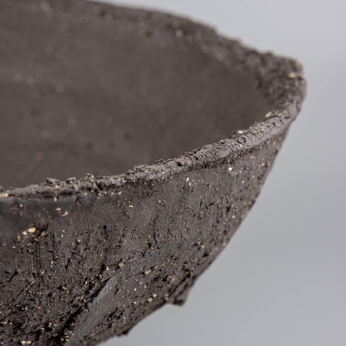 Handmade decorative bowl macro texture with charcoal clay, mineral speckles, and limited edition decor appeal.