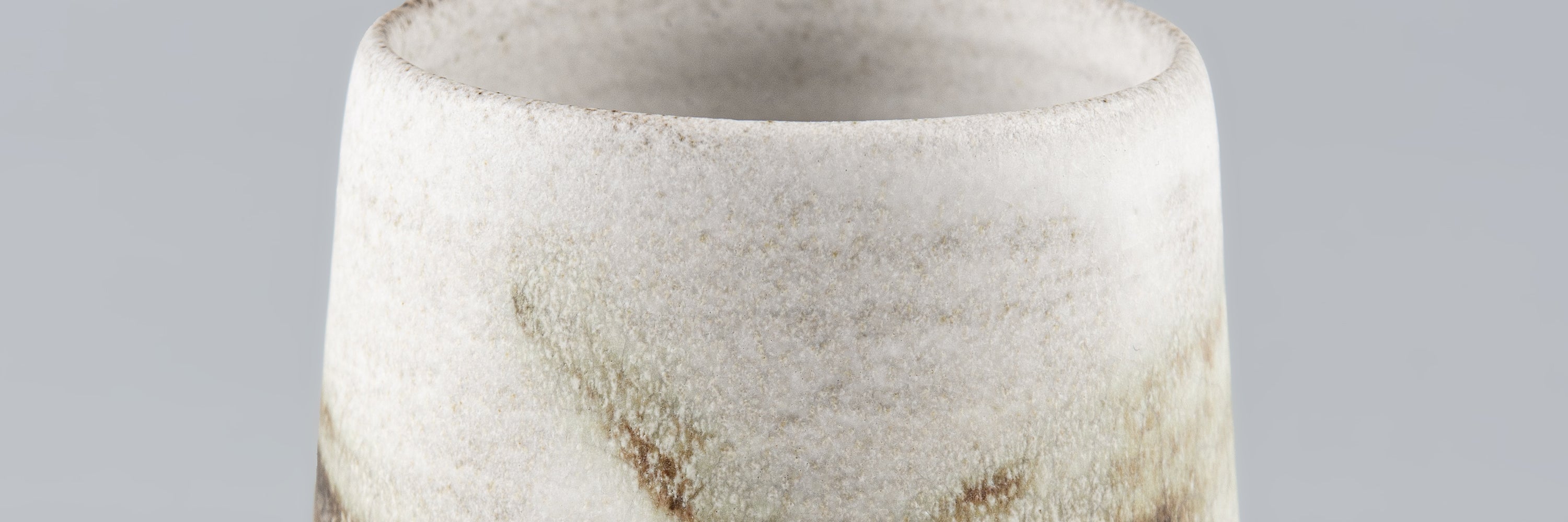 Handmade ceramic cup in artisanal white stoneware with subtle brown speckles, Stonessa design for modern coffee and espresso rituals.